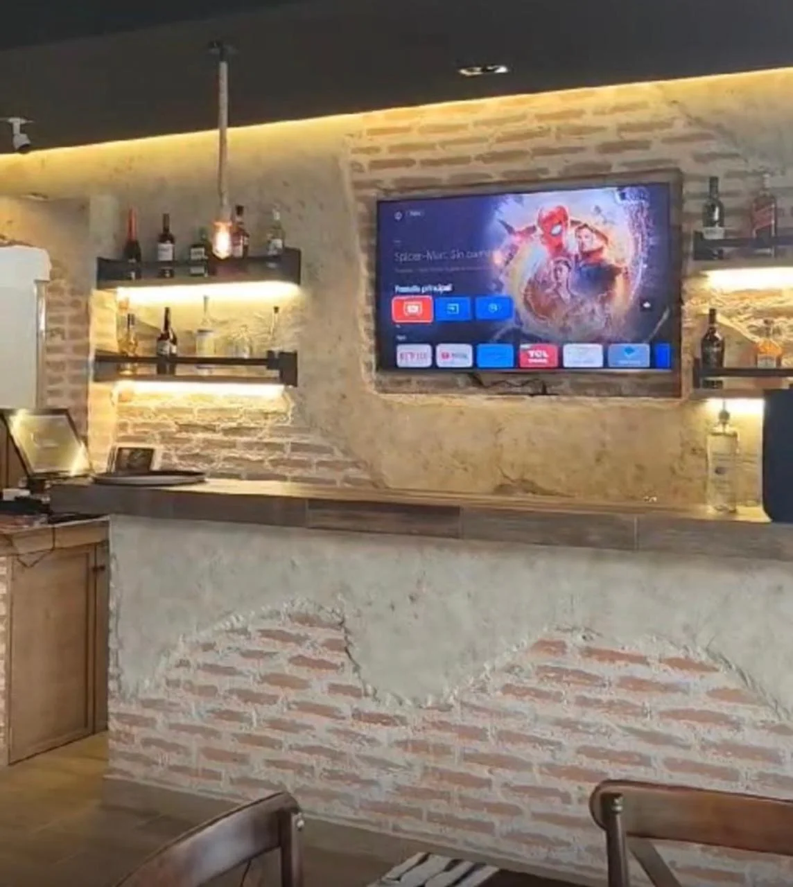 Bar recreativo con muros de ladrillo aparente e iluminación integrada