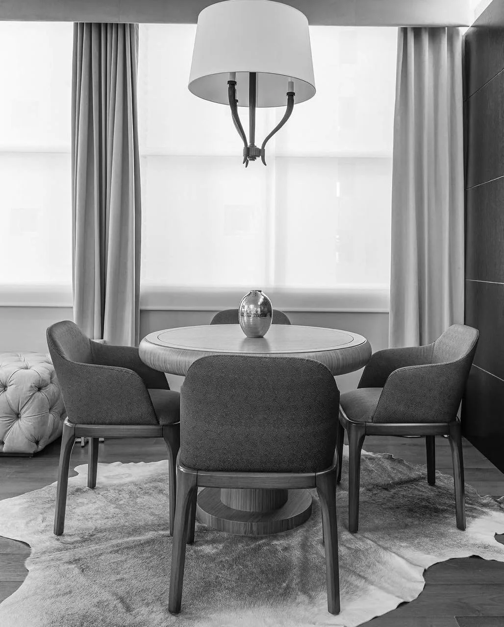 Comedor residencial con mesa redonda frente a grandes ventanales